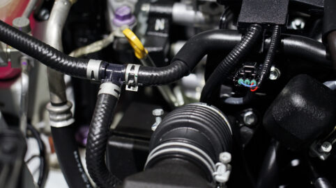 Close-up of a rubber crankcase valve inside the engine of a car.