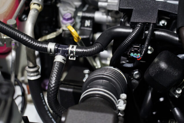 Close-up of a rubber crankcase valve inside the engine of a car.