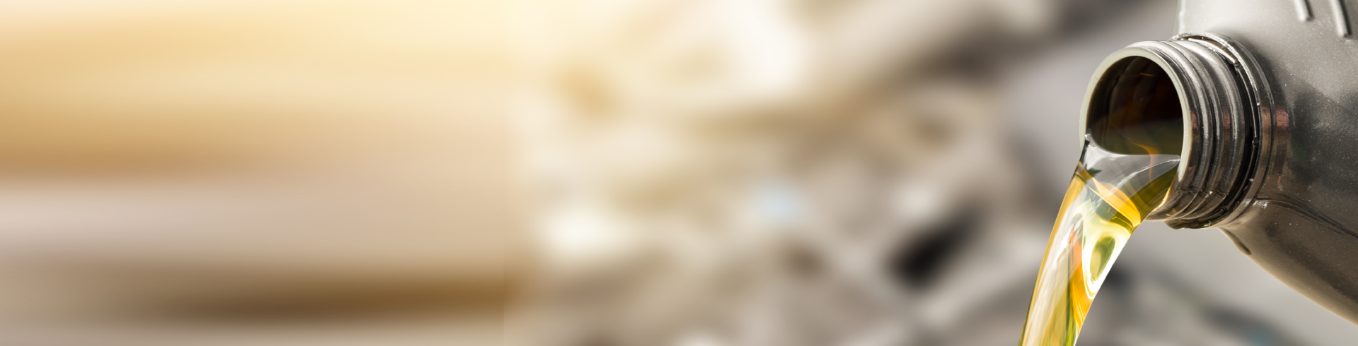 An image of Fresh oil being poured into a car during an oil change.