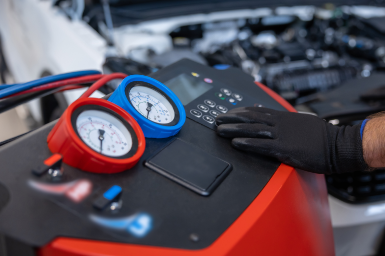An A/C equipment system with gauges in an auto repair shop that specializes in BMWs.