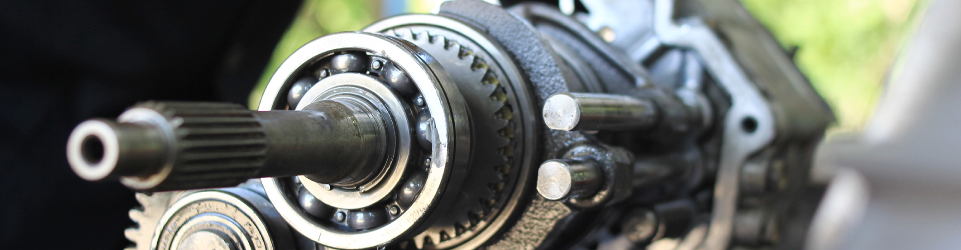 Hand of a car mechanic, fixing the disassembled gear parts of a BMW transmission.