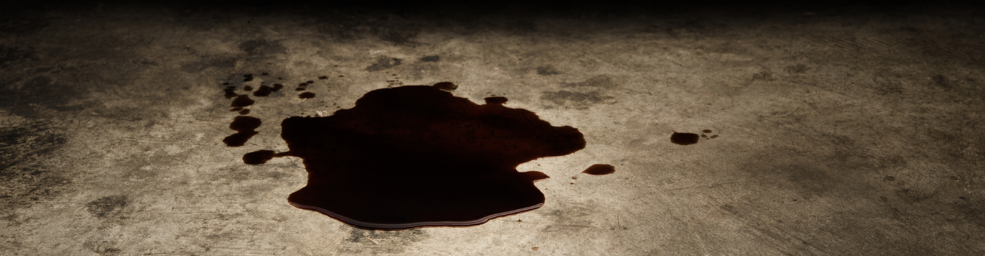 An oil leak puddle from the BMW engine on the concrete floor.