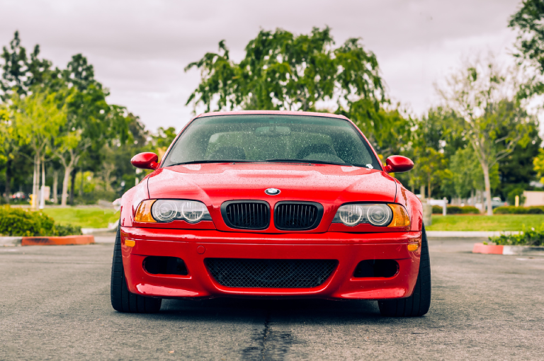 Red BMW E46 M3 parked, showing the front of the car.