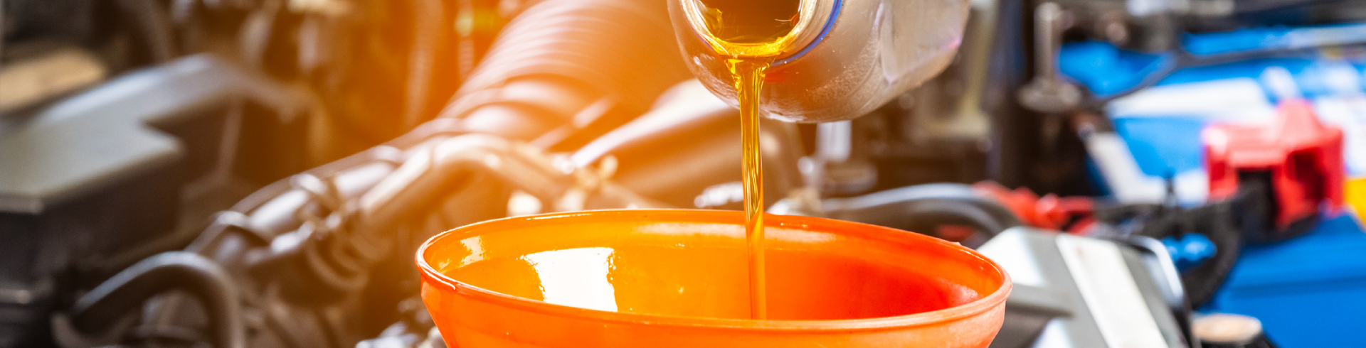 Mechanic performing Audi oil change, pouring oil into a funnel.