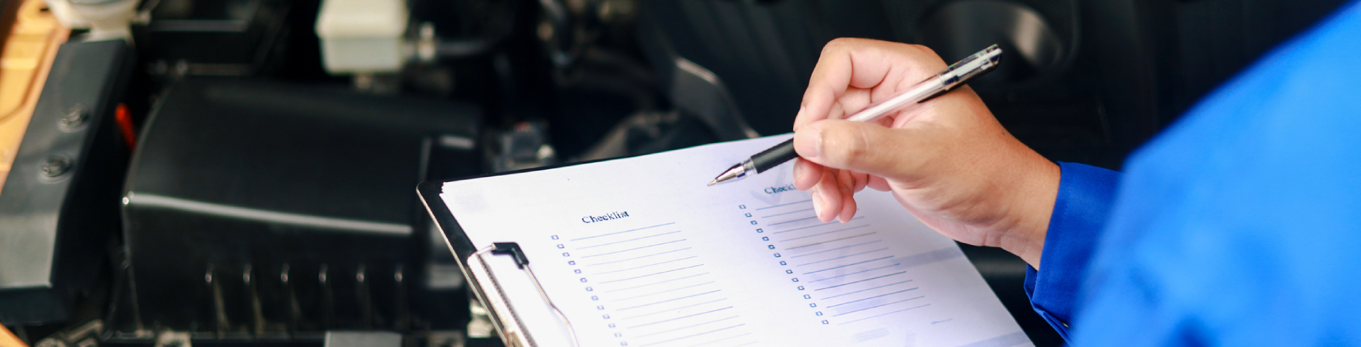 Auto technician with a clipboard is checking the engine during Audi pre-purchase inspection.