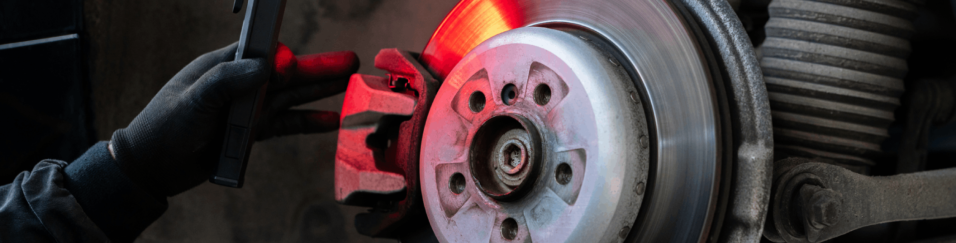 Close up of hands of serviceman performing Mercedes brake repair, checking the brake discs of a car.