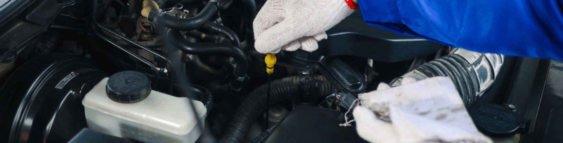 A mechanic performs a dip-stick test as part of a MINI Cooper oil change.