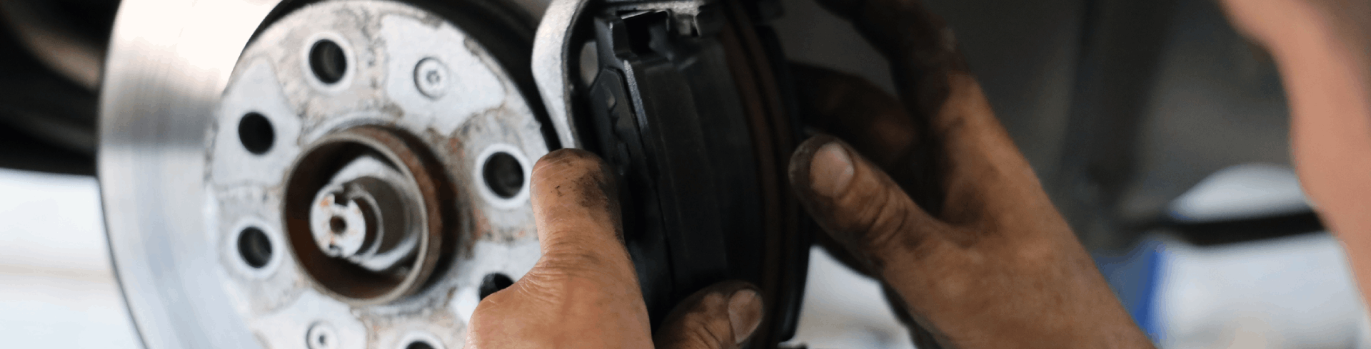 Mechanic performs brake pad replacement on MINI Cooper.