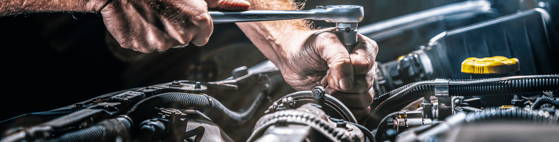 Auto mechanic working on repairing Mercedes engine in garage.