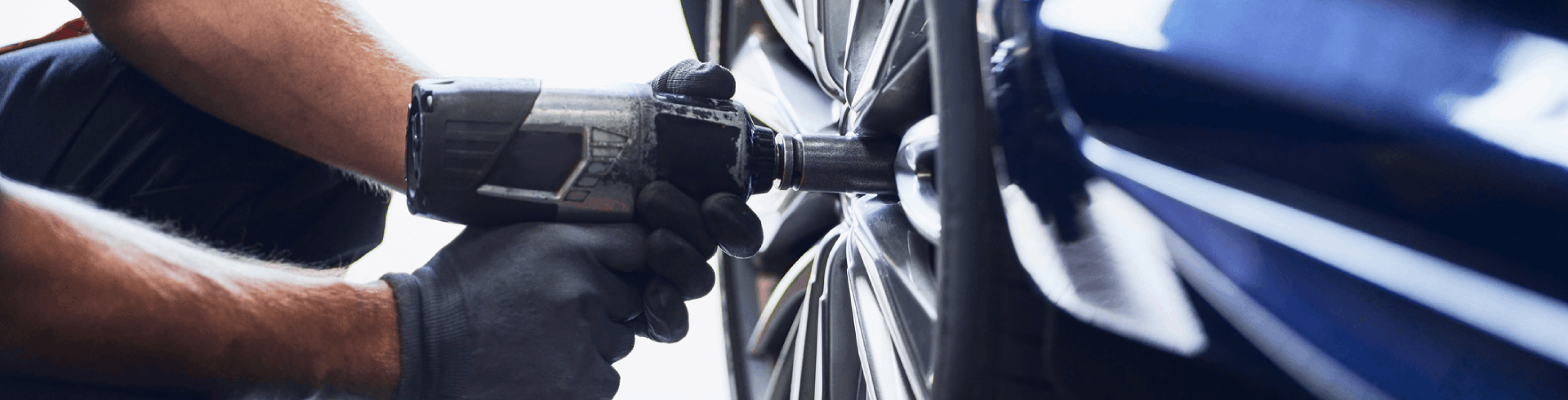 Close-up shot of a mechanic putting new tires on a MINI Cooper.