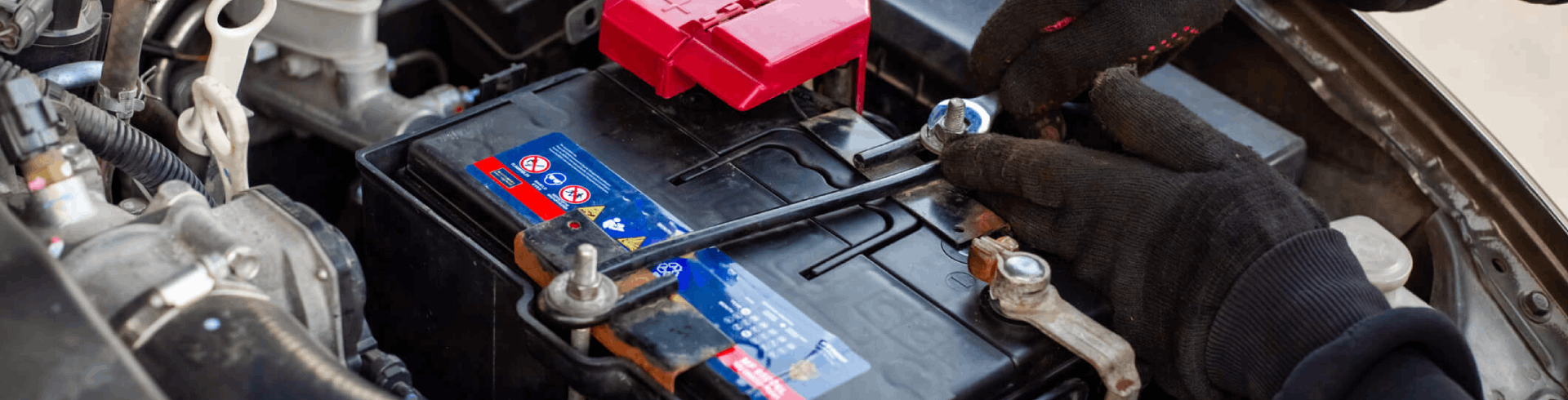 Professional mechanic replaces a car battery in a Volkswagen vehicle.