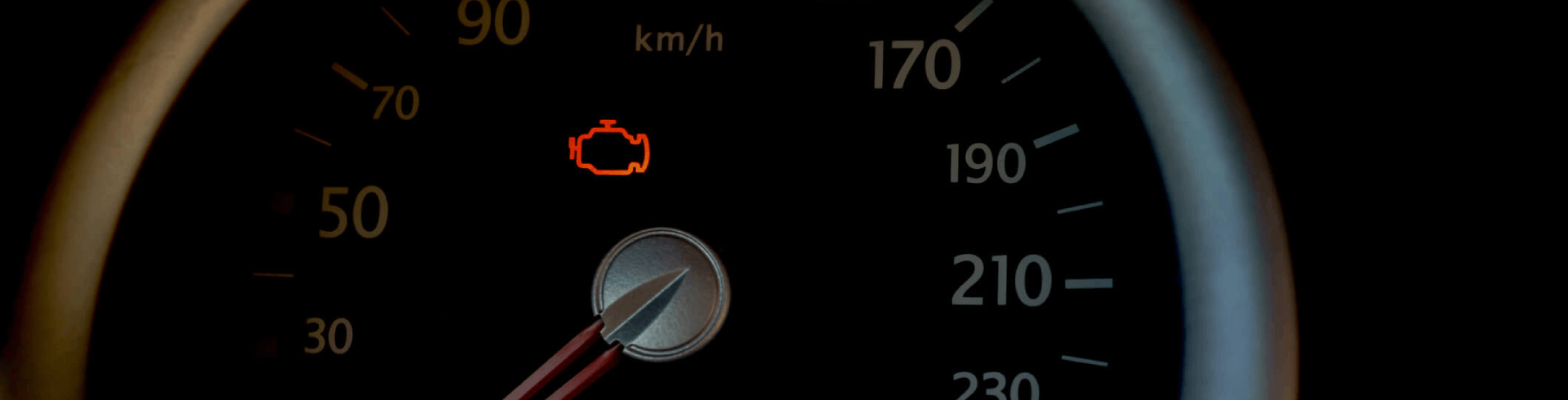 A check engine light is illuminated on a vehicle’s dashboard.