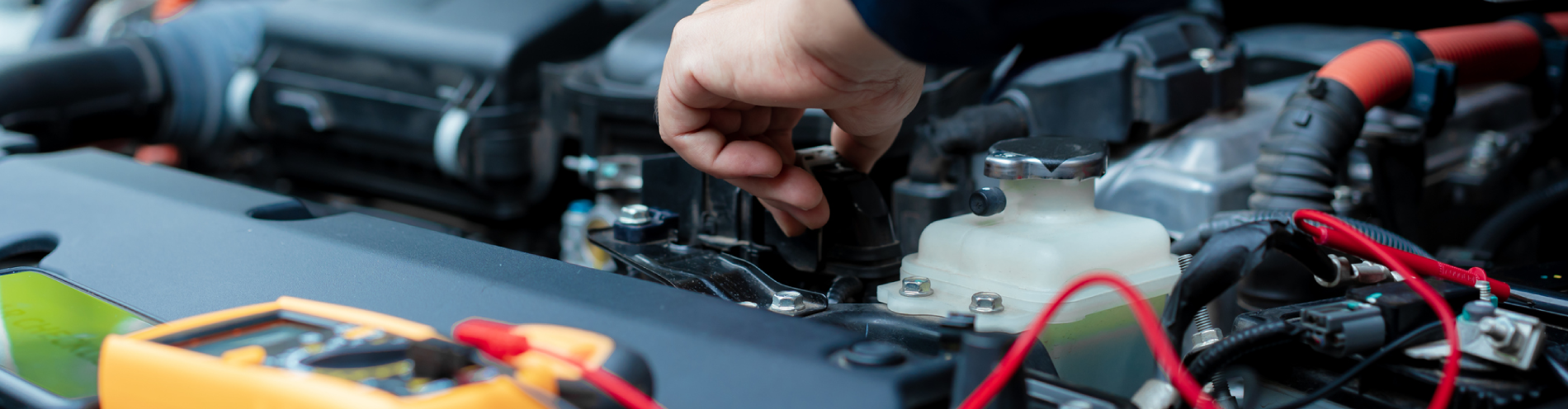 An automotive technician inspects vehicle’s electrical systems using a variety of tools.