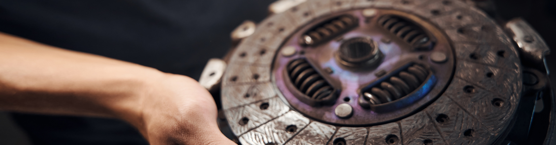 Close-up of mechanic holding a clutch disc.